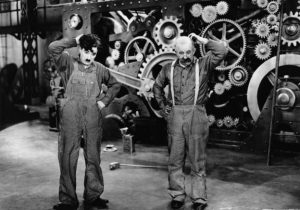 Image les temps modernes 2 hommes en réflexion devant une machine à angrenage